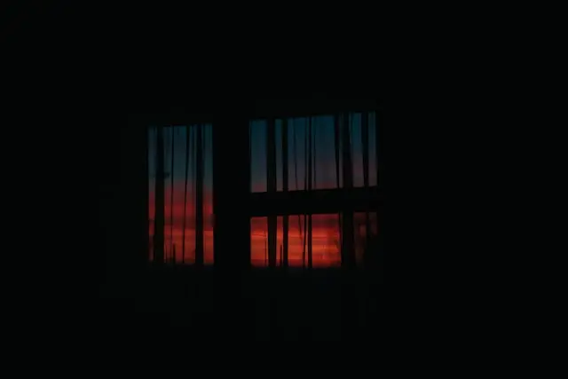 Ventana de noche vista desde adentro de una habitación oscura