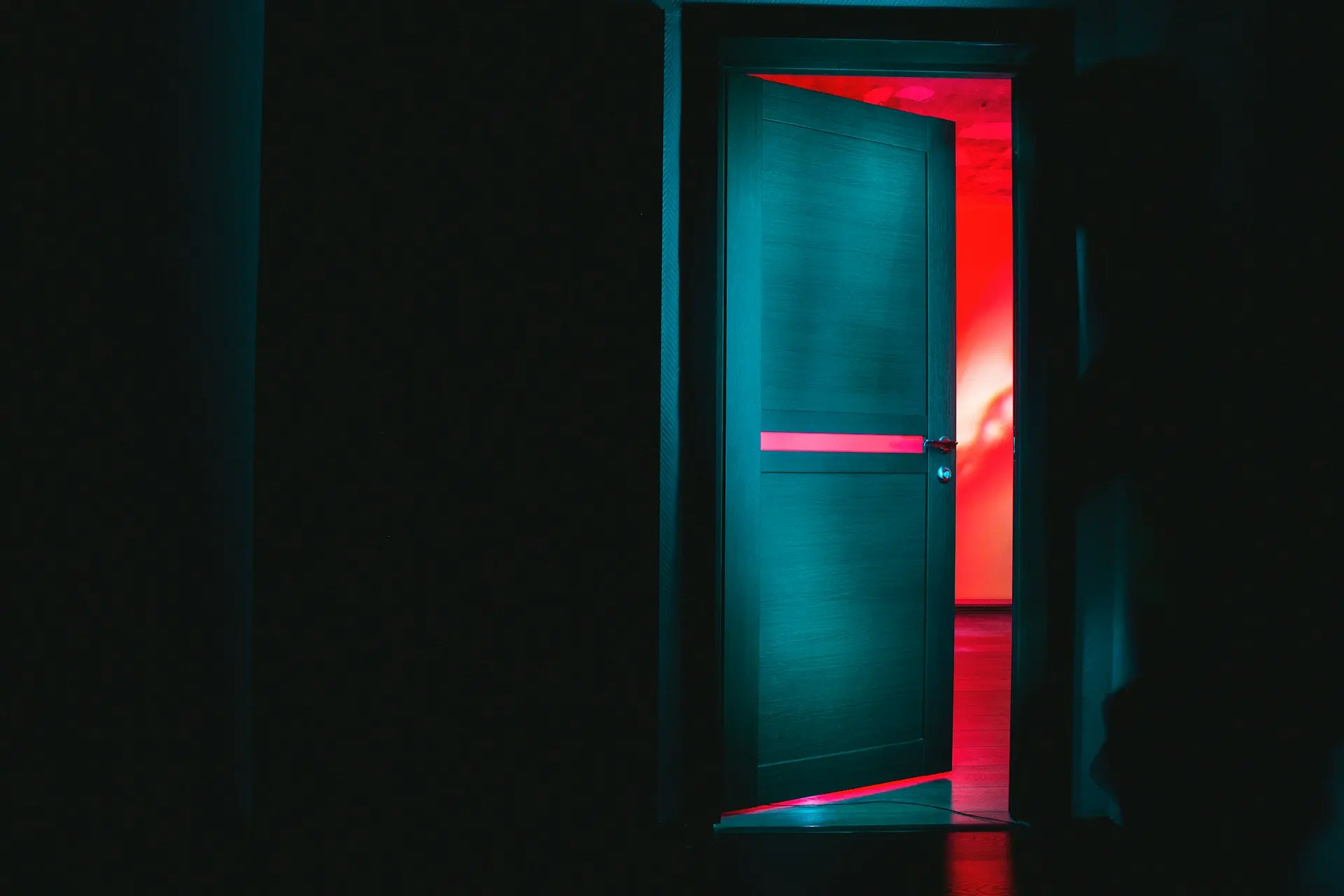 Qué es un psicoanálisis: Una puerta entreabierta con luz tenue en un pasillo